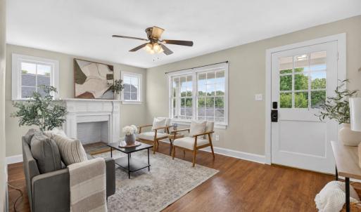 Bright living room with beautiful hardwood floors and a wood-burning fireplace.
