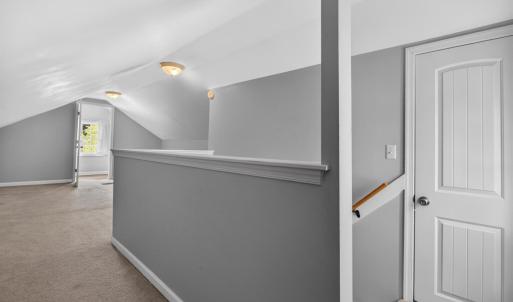 Spacious carpeted bedroom loft with sizable closet and multiple attic access is with ample storage and a private half bath.