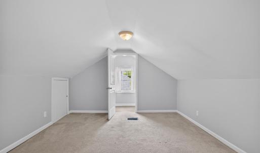 Spacious carpeted bedroom loft with sizable closet and multiple attic access is with ample storage and a private half bath.