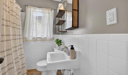 Charming bathroom with tile backsplash and fresh paint.