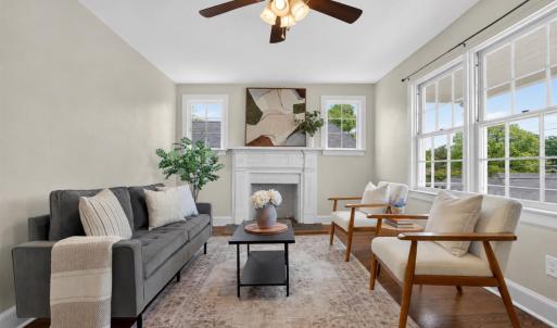Bright living room with beautiful hardwood floors and a wood-burning fireplace.