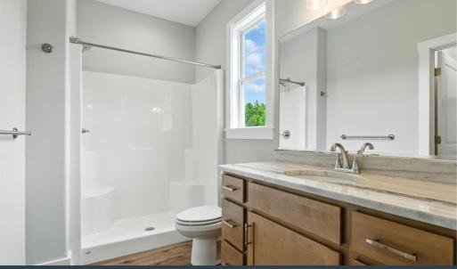 Primary Bathroom - En Suite with Fiberglass shower, vanity, and WIC