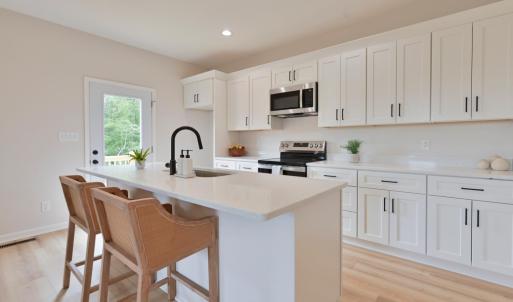 Open Concept kitchen with quartz counters, oversized island, door to deck, etc *Fridge ordered and scheduled to be installed.
