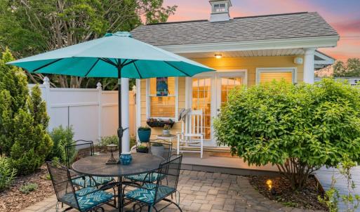 Charming pool house overlooking the patio and pool area, perfect for relaxing or storing pool essentials.