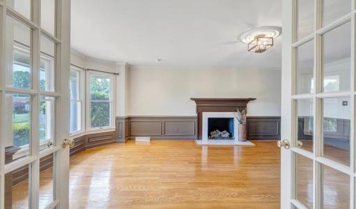 Living room accented by a gas log fireplace and large bay window