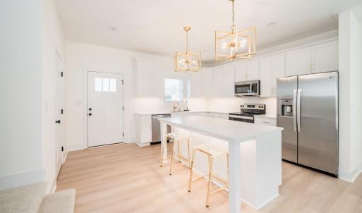 Open kitchen with 6 ft island, under cabinet lighting, white shaker cabinets and quartz countertops.  Similar to photos.