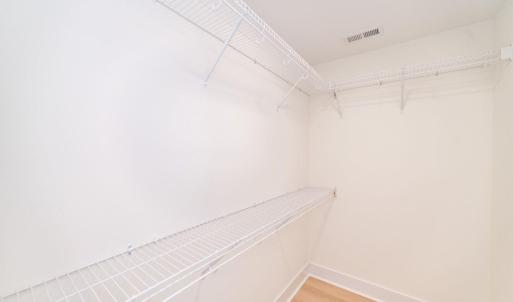 Walk in closet in primary bedroom.