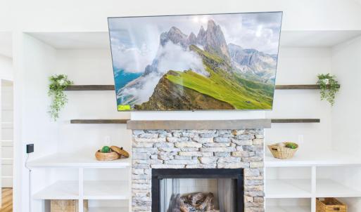 Stone Fireplace with Custom Built-In Shelving creates a warm focal point for the Open Living Area.