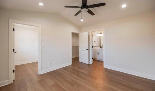 Primary Suite with vaulted ceilings, walk in closet and en suite full bathroom.