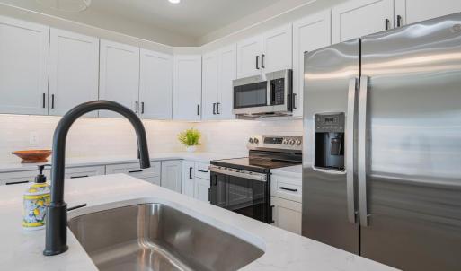 Custom kitchen with quartz counters, tile backsplash, all stainless applicants includes. Finishes may not be exact, but will be similar.