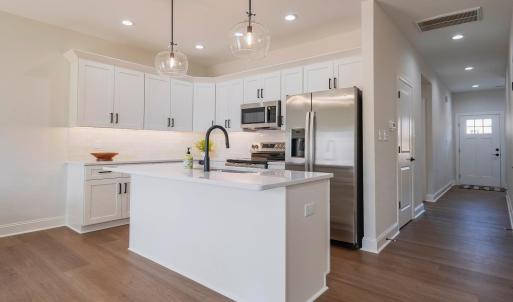 Open concept, custom kitchen. Tile backsplash, open to dining and living area. Finishes may not be identical but similar.