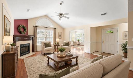 Virtually staged living room leading into the sunroom