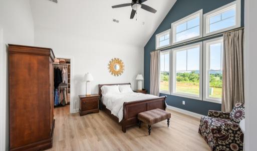Main level primary suite with natural sunlight, large window, and mountain views