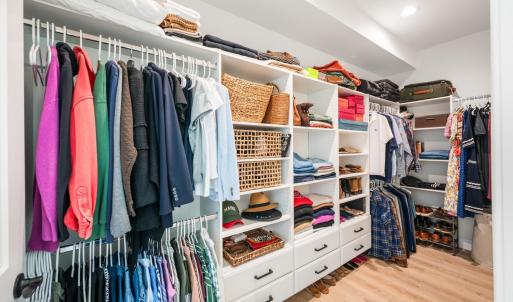 Primary walk in closet with added drawer space for more storage.