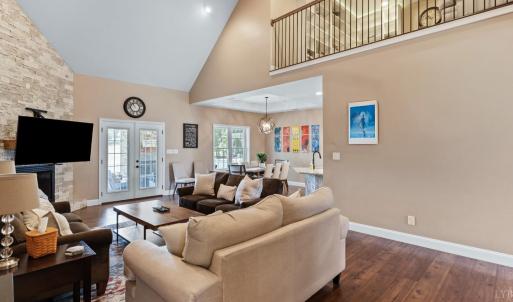 Living room with vaulted ceiling and stone wall fireplace.
