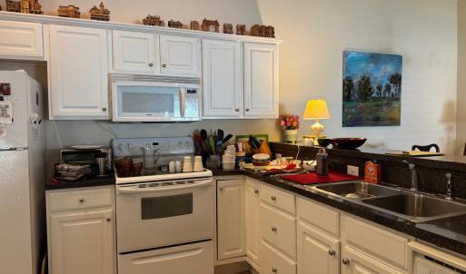 The kitchen layout is spacious and well equipped. Refrigerator, microwave, electric stove and D/W convey. This is on the other side of the Dining Room area.