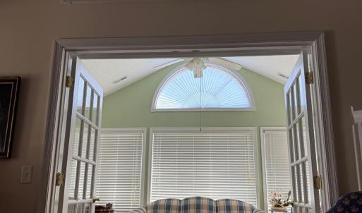 The SUNPORCH!! 3 walls of windows, french doors to close it off from the greatroom, double Palladian windows, and built in shelves around the entire wall with the french doors!