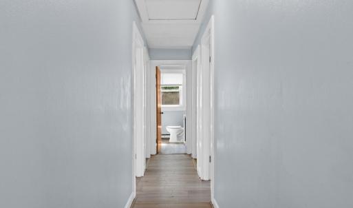 Heading down the hall to bedrooms, bath, kitchen, slider to deck! Pull down attic door here in the hallway