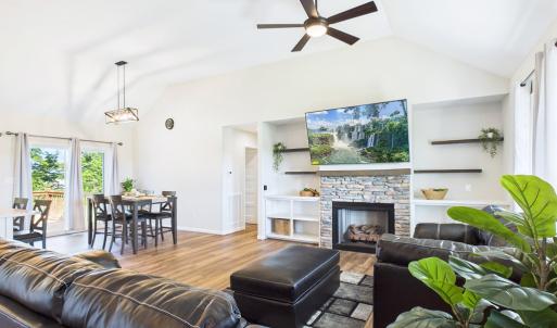 Interior , Open Floor Plan featuring Vaulted Ceilings, Stone Fireplace, Built-In Shelving, Luxury Vinyl Plank Flooring, and abundant Natural Light.