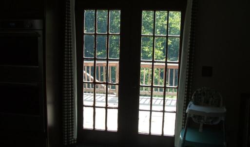 French doors lead from kitchen/dining area to deck