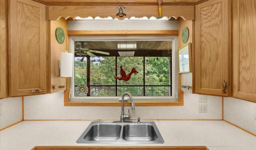 Primary Kitchen - Main Floor, The roll-out window expands the kitchen by inviting summer dining on the porch.