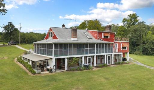 Southeast Side of home, Screened Porches expand the living space into the outdoors on the main and lower levels, with a greenhouse attached