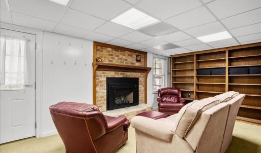 Living Room - Suite 2 Basement, Library shelves and gas logs in the fireplace encourage sneaking away for a good read.
