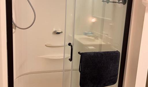 Walk-In Shower In Bathroom Attached To Primary Bed