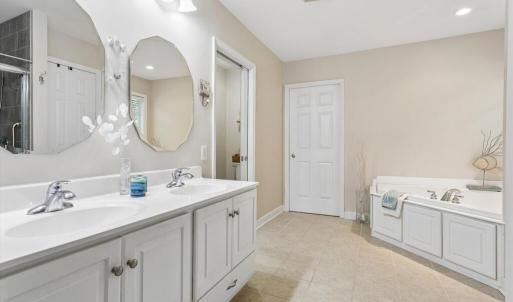 Primary Bathroom w/dual sinks, walk-in tile shower, and large soaking tub.