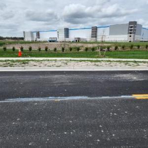 Road dividing Amazon Fullfillment Center and subject property