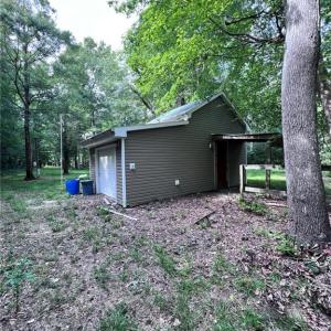 Storage shed with lean to for equipment.