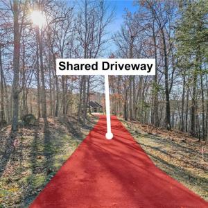 See pink flags to right and left of asphalt driveway for the marked easement.  Lot is located at end of shared driveway to the right on peninsula.