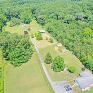 Cleared property on left with the long driveway back to the house on on right side behind the adjacent property. There are two mobile homes on this site. The property on the right side (front 2 acres) is also for sale owned by a different person.