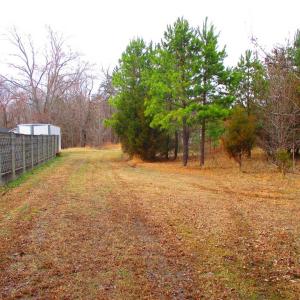 Asphalt drive ends and becomes a field.