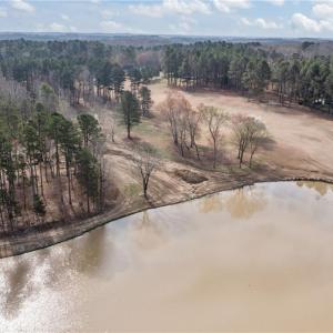 Overhead view showing the vacant land and lake. Lot lines and dimensions are approximate.