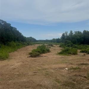 Expansive vacant acreage with a mix of cleared and wooded areas.