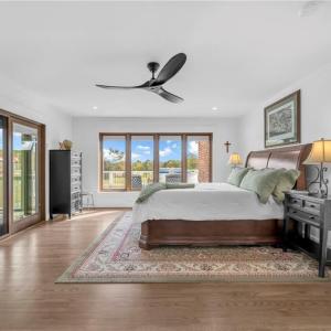 Primary bedroom w/ ceiling fan and direct access to the screen porch