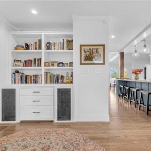 Sitting room adjacent to foyer w/ built in display shelves/bookcase and cabinet storage