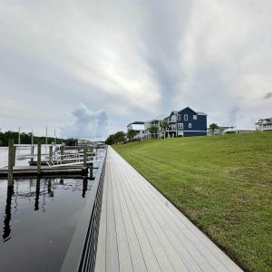 View of dock with a lawn and a water view