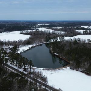 Snowy aerial view featuring a water view