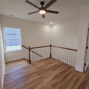 Empty room with a ceiling fan, visible vents, base