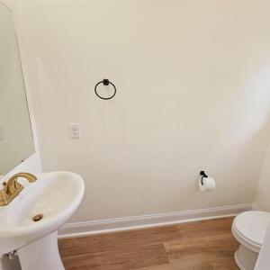 Bathroom featuring baseboards, a sink, toilet, and