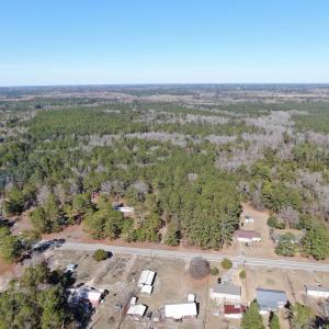 Birds eye view of property with a wooded view
