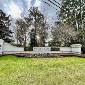 Community / neighborhood sign featuring a lawn
