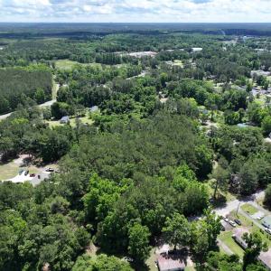 Birds eye view of property with a wooded view