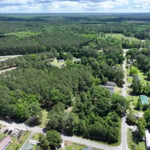 Birds eye view of property featuring a wooded view