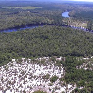 Bird's eye view of a heavily wooded area and a lar