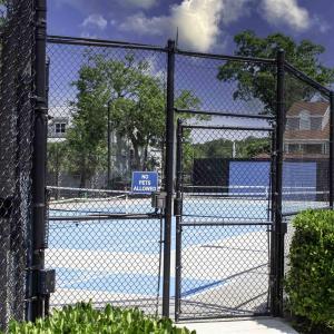 View of tennis court with a gate