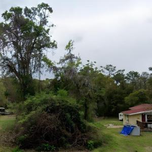 View of green lawn featuring a wooden deck