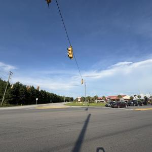 View of asphalt street with traffic lights and tra